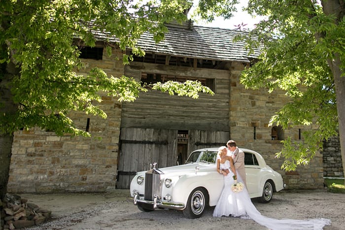 Groom and Bride Standing Next to Luxury Car